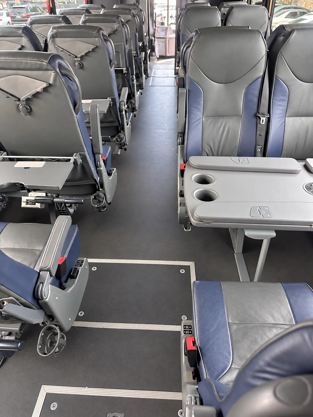 Fold-down tray tables deployed on the seatbacks inside the Four Season Travel Mini Coach cabin