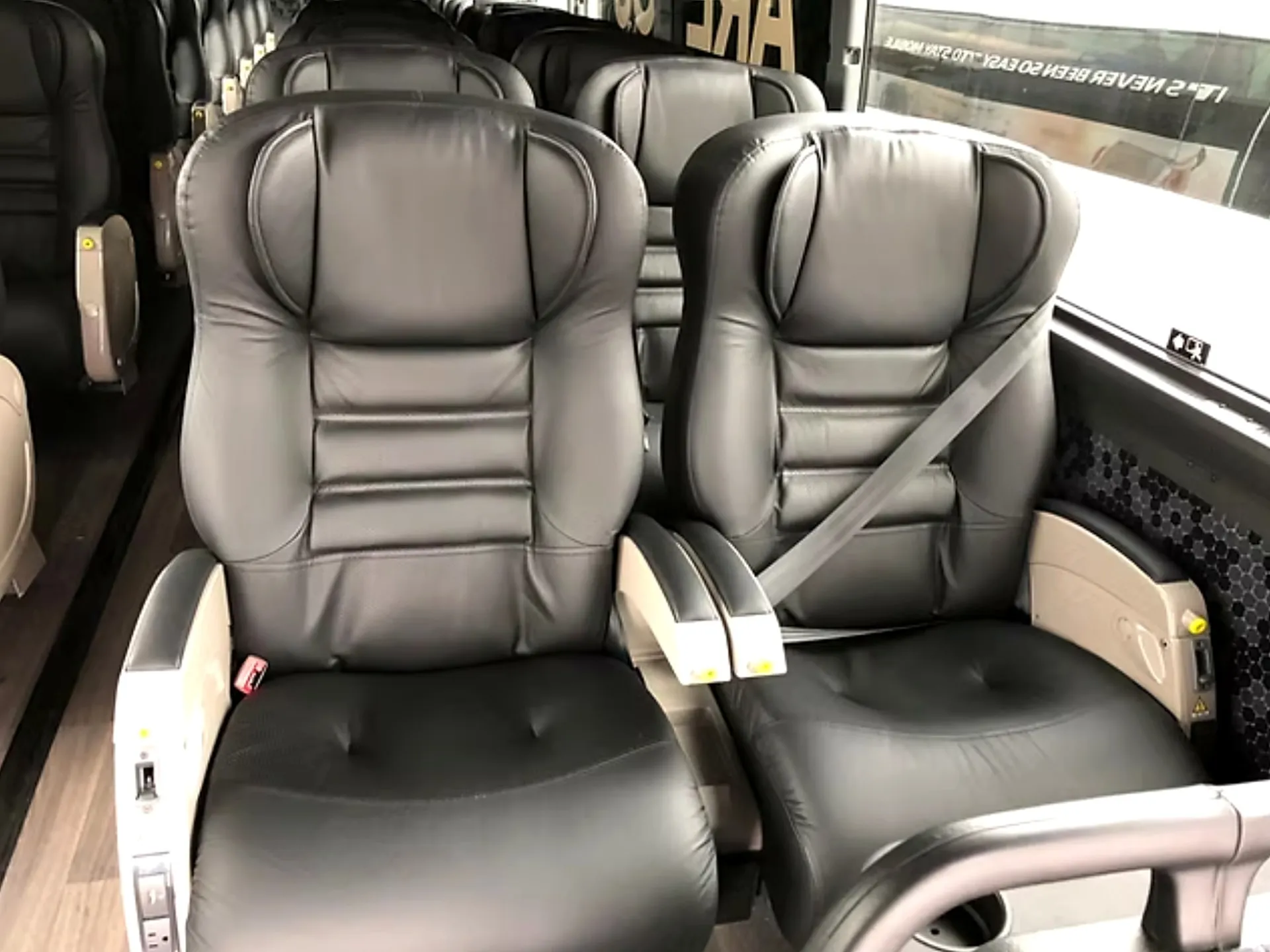 Close view of premium leather reclining seats with armrests and seatbelts in the Four Season Travel VIP coach
